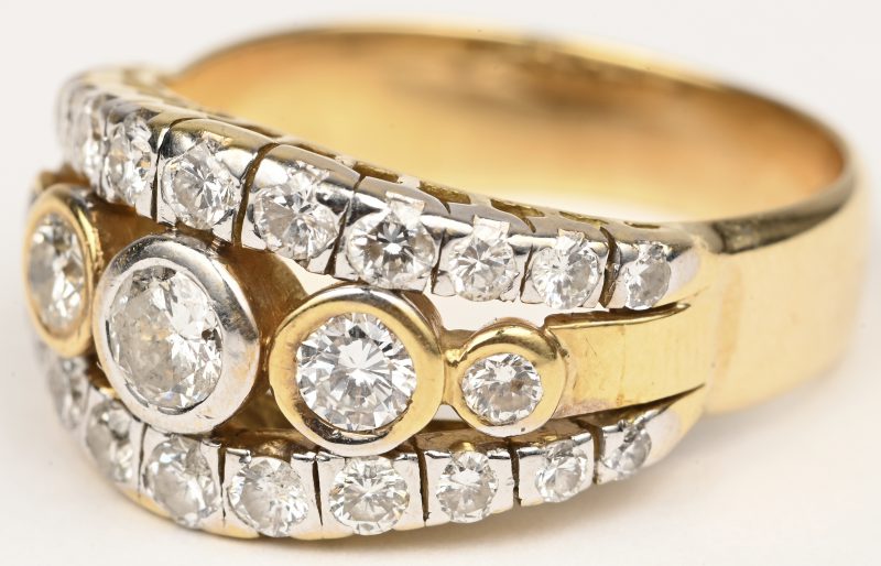 Een 18 kt wit en geelgouden ring bezet met twee briljanten met een gezamenlijk gewicht van +- 1 ct.