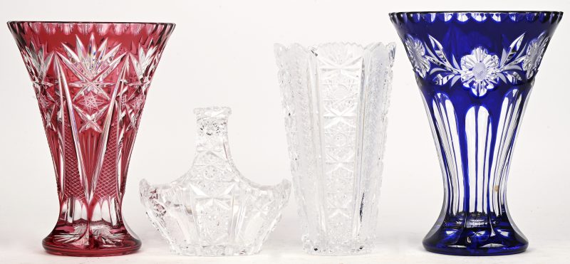 Een lot van 4 stuks Boheems kristal bestaande uit: 1 blauw en kleurloze vaas, 1 roze en kleurloze vaas, 1 kleurloze vaas en een kleurloos mandje.