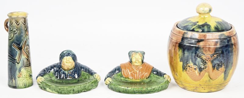 Een lot van vier stuks Vlaams aardewerk. Bestaande uit twee vide-poches in de vorm van een boerenkoppel, een tabakspot en een klein fluitvaasje.