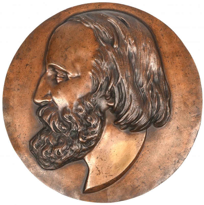 Een bronzen plaquette van een bebaarde man, niet gesigneerd.