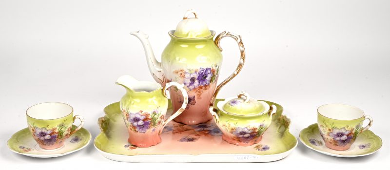 Een porseleinen tête-à-tête, ca 1900 bestaande uit een theekannetje, melk- en suikerpot, 2 tassen met ondertas en een dienbladje.