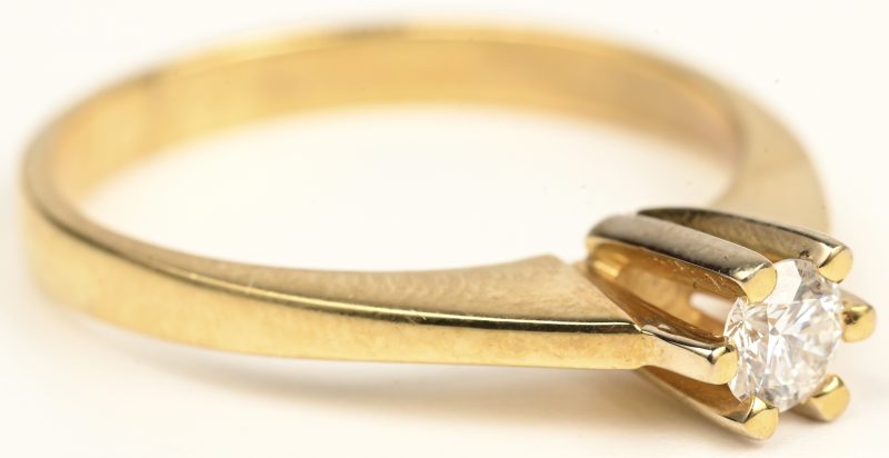 Een 18 kt geelgouden ring bezet met centrale briljant van +- 0,18 ct. FVS1 en briljanten met een gezamenlijk gewicht van +- 0,53 ct.