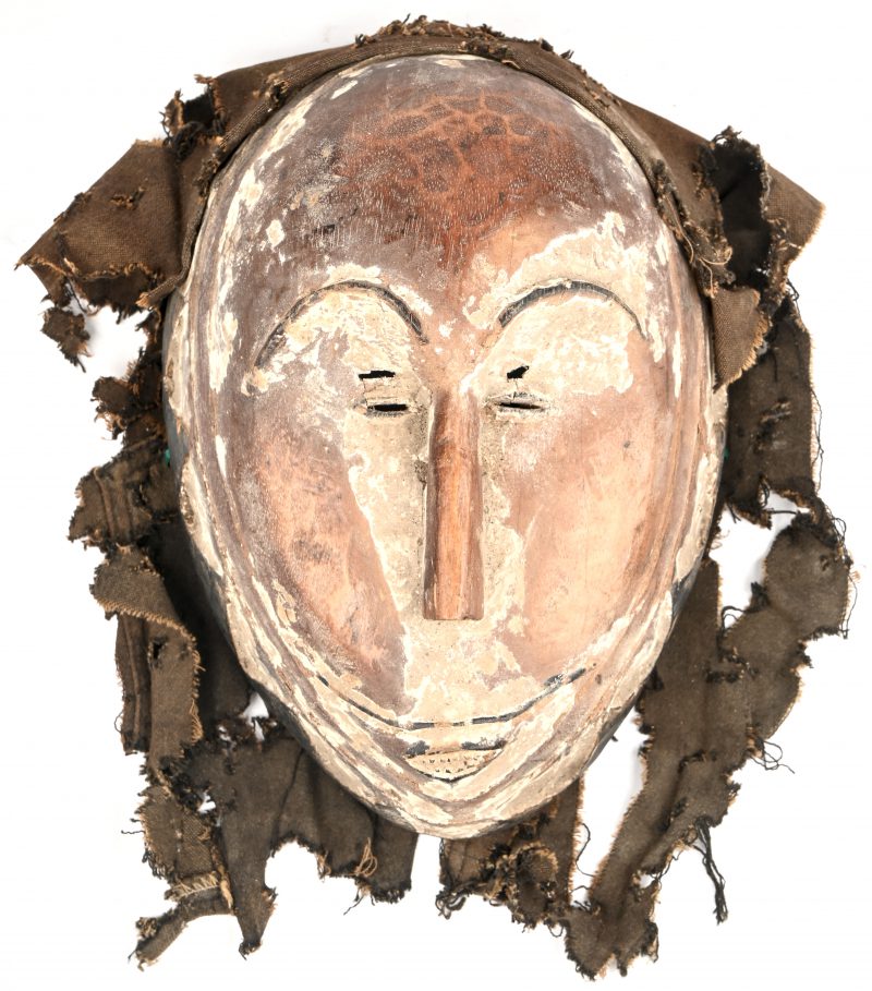 Een gepatineerd uit hout en textiel gesculpteerd masker. Origine Punu, Gabon.