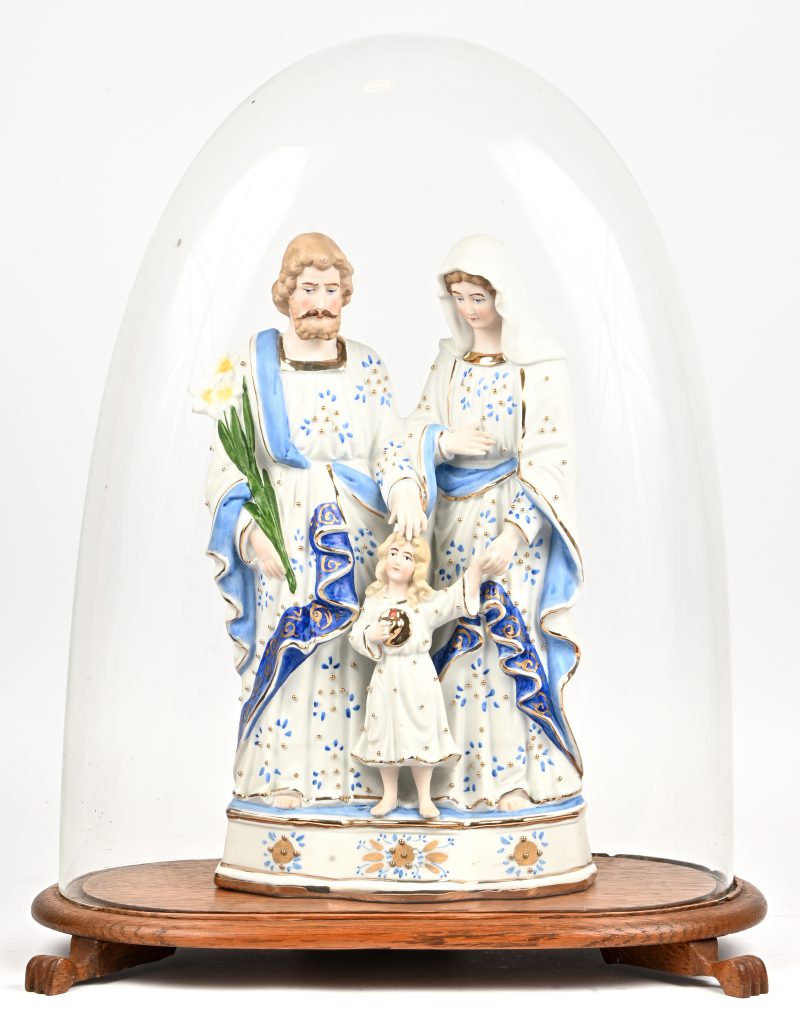 Een oude glazen stolp met een biscuit beeld van de Heilige Familie.
