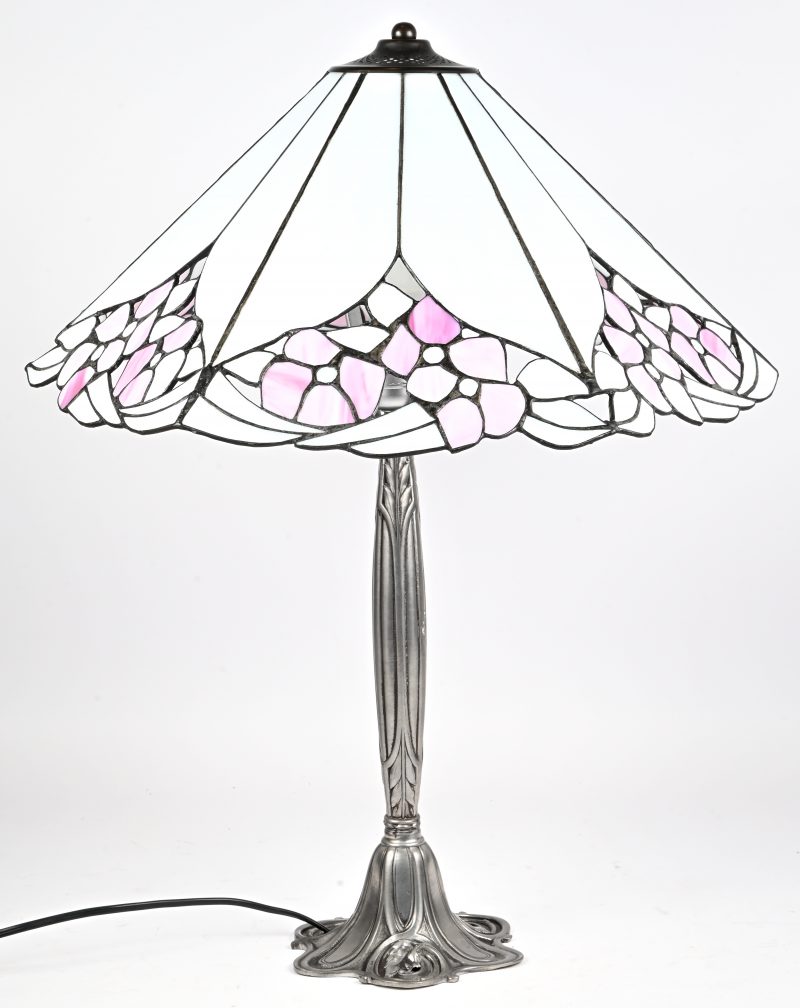 Een retro tafellamp met metalen voet en in Tiffany stijl glas in lood kap.