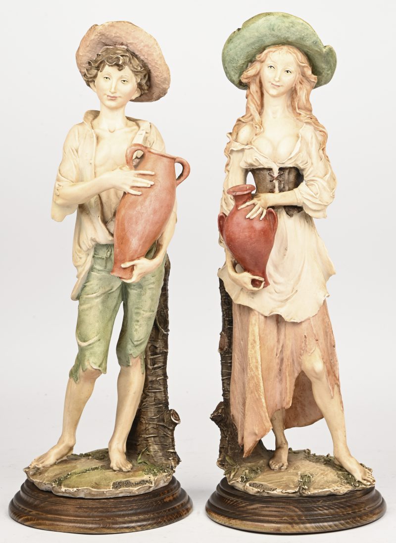 Een set van 2 kunststof beelden voorstellend een jongen en een meisje. G. Armani, Capo Di Monte.