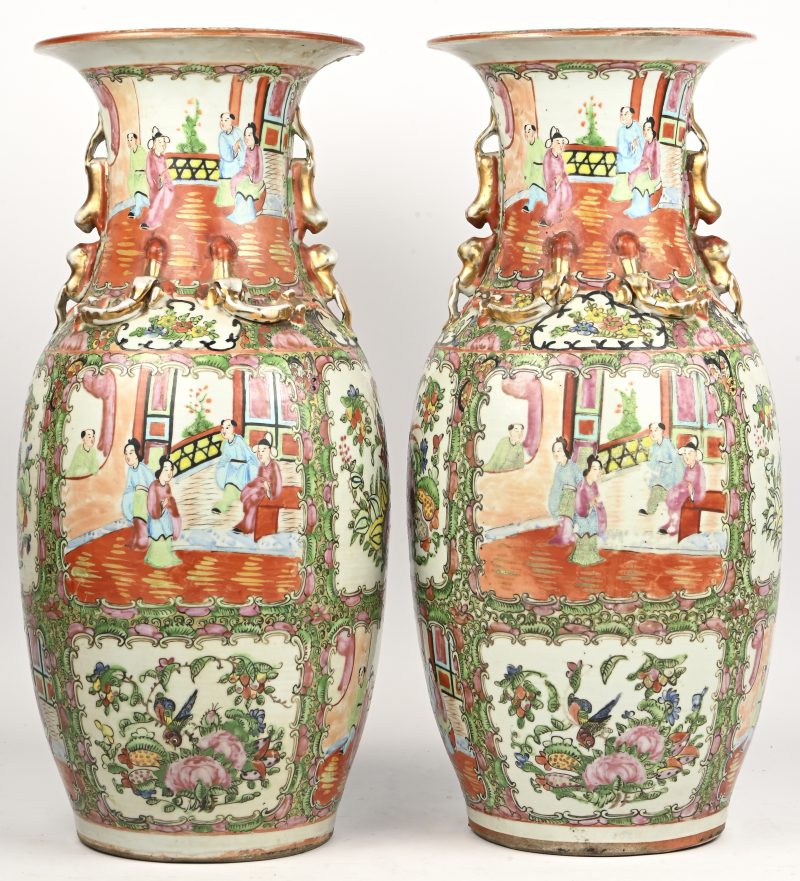 Een paar Chinees porseleinen vazen meerkleurig versierd met paleistafereel in het decor en vergulde ornamenten. 1 vaas met breukherstel aan de bovenrand.