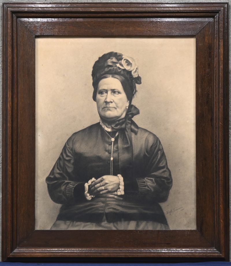 “Portret van een oudere dame”. Een met houtskool gehoogde foto van een zwartgeklede dame. Onderaan gesigneerd.