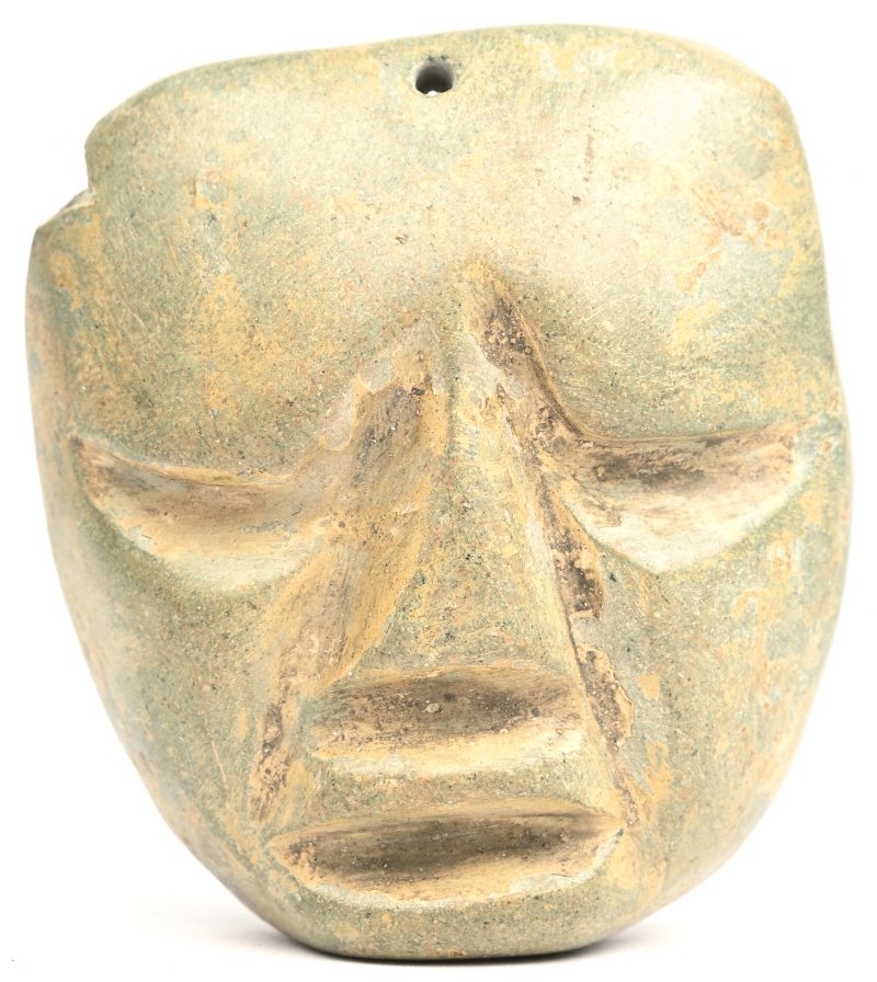 Een uit steen gesculpteerde Maya medaillon van een gelaat. Verso label met vermelding; “Gevonden in de piramide van Chicen-Itza, (Mexico)”.