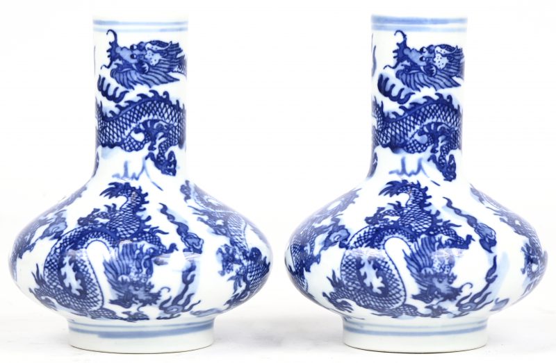 Een paar klein Chinees porseleinen vaasjes met blauw drakendecor. Onderaan gemerkt.