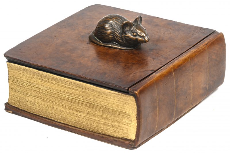 Een vierkant kunststoffen doosje in de vorm van een boek in trompe l’oeil met bovenop een muis.