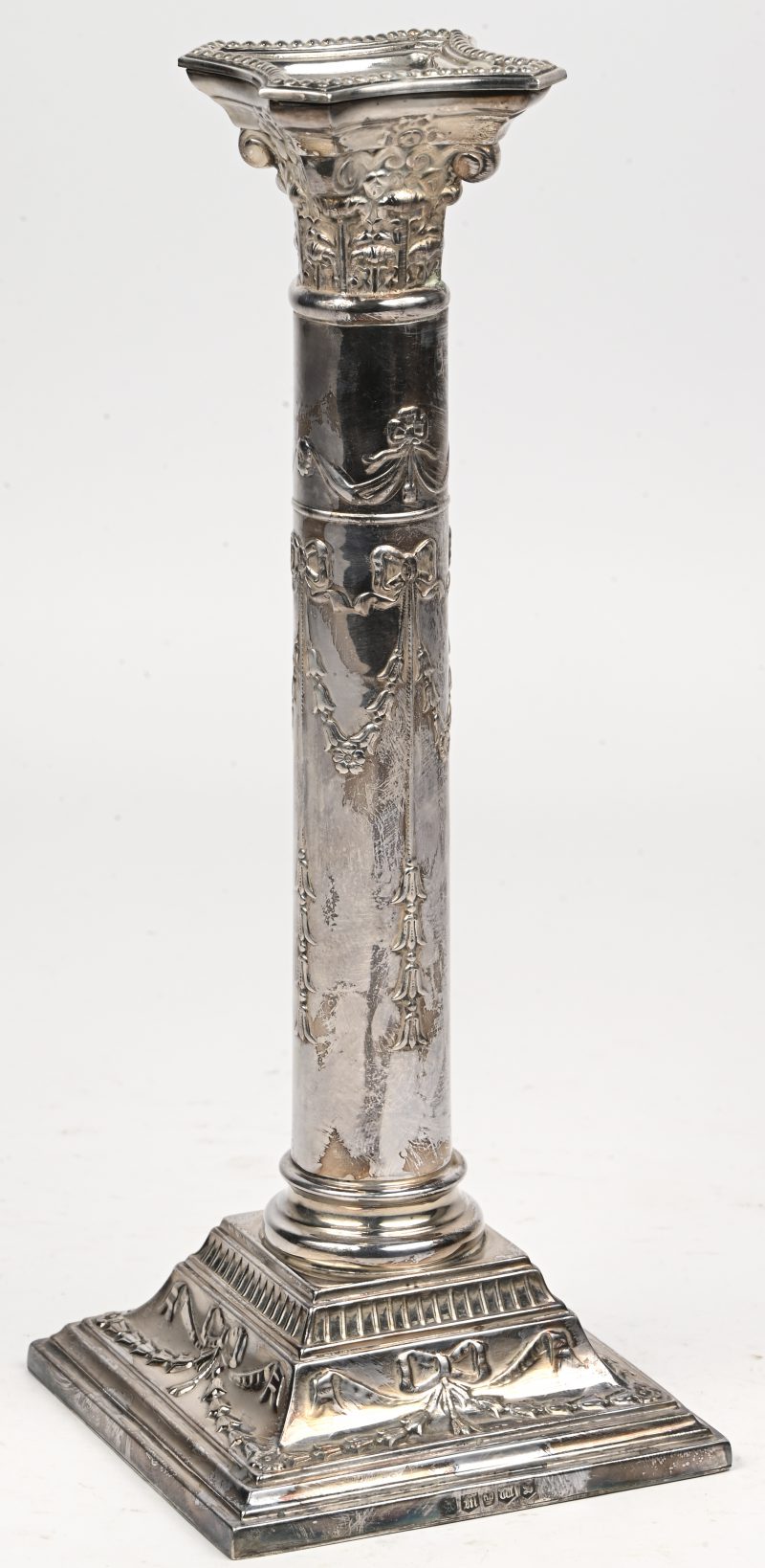 Een verzilverd metalen kandelaar in de vorm van een Korinthische zuil naar Engels voorbeeld.