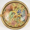 Een meerkleurig en verguld aardewerken schaal, versierd met draken, vogels en florale details, onderaan gemerkt. Bijgevoegd een Engels porseleinen Staffordshire vaas.