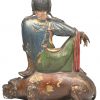 ‘Zittende Buddha op een tempelleeuw’. Een beeld in gepolychromeerd brons.