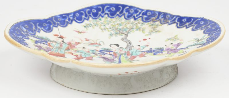 Een schaaltje van Chinees porselein met een famille rose decor binnen een powder blue rand. Hoge zool.