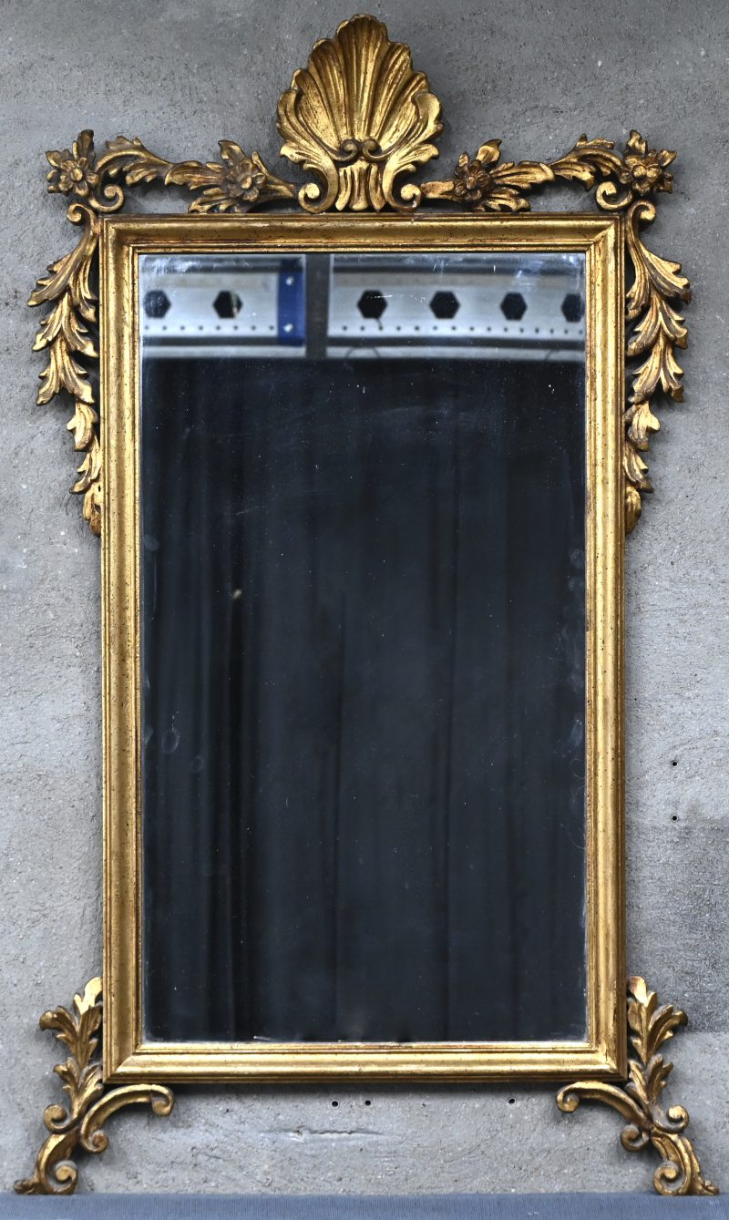 Een Italiaanse spiegel met verguld kader en gesculpteerde elementen. Eind 19e eeuw.