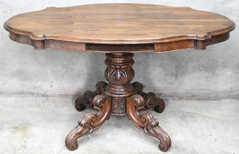 Een houten tafeltje met gefineerd blad en gesculpteerde voet. 2 laden manco.