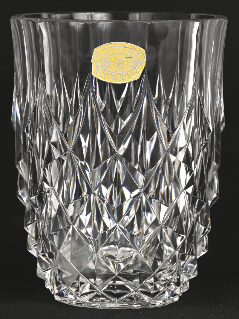 Een kleurloos kristallen vaas onderaan gemerkt Val Saint Lambert, draagt eveneens een merksticker. Vertoond kleine schilferschade aan de bovenrand.