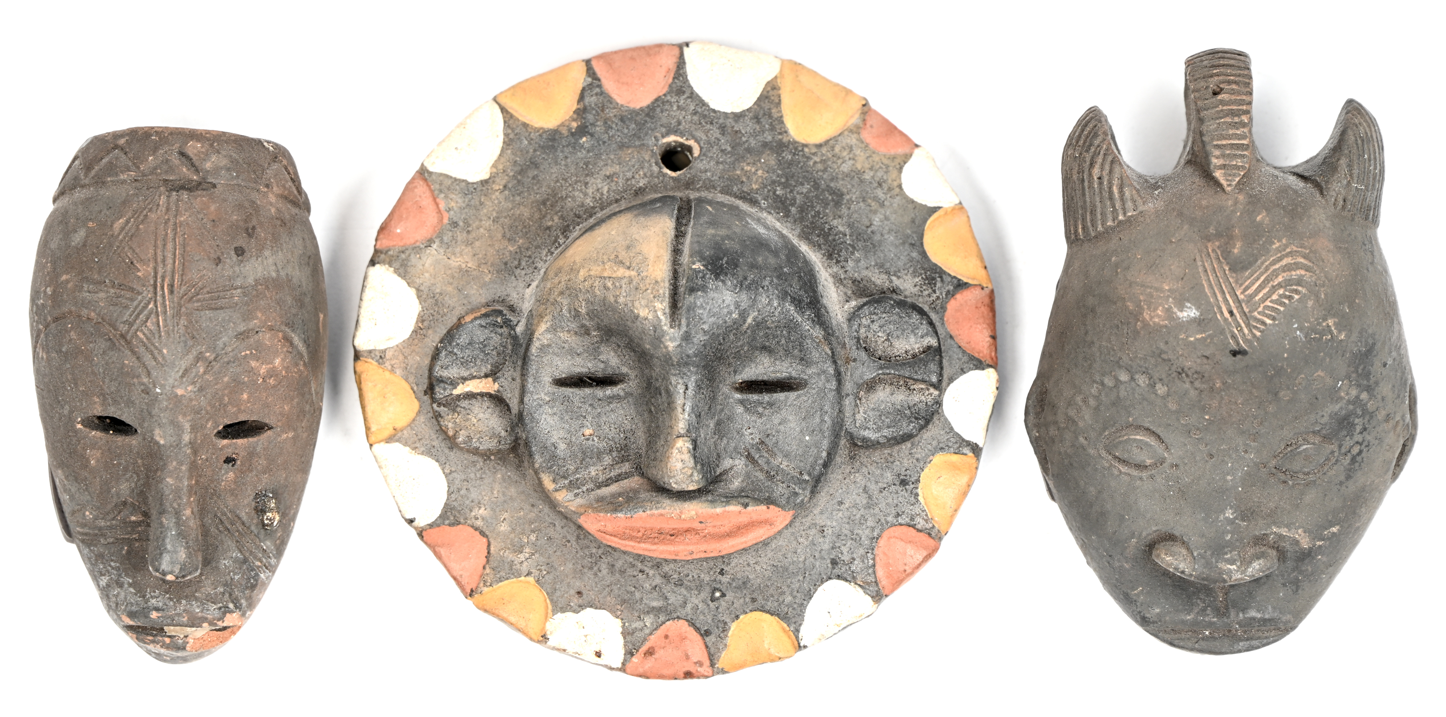Een lot van drie Afrikaanse miniatuur maskers in aardewerk.