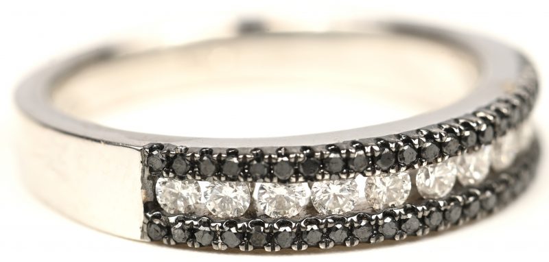 Een 18 kt witgouden ring bezet met zwarte en witte briljanten met een gezamenlijk gewicht van +- 0,48 ct.