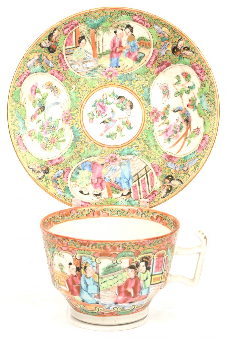 Een Kanton porseleinen kopje met schoteltje, meerkleurig versierd met diverse figuren, dieren en floraal decor. Begin 19e eeuws.