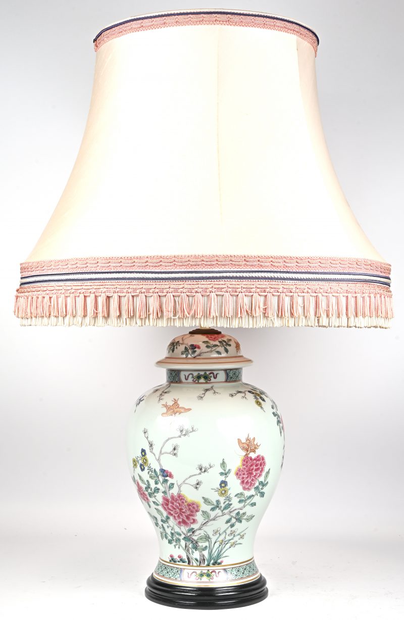 Een tafellamp met als voet een Chinese dekselvaas met het decor van bloeiende struiken en vlinders.