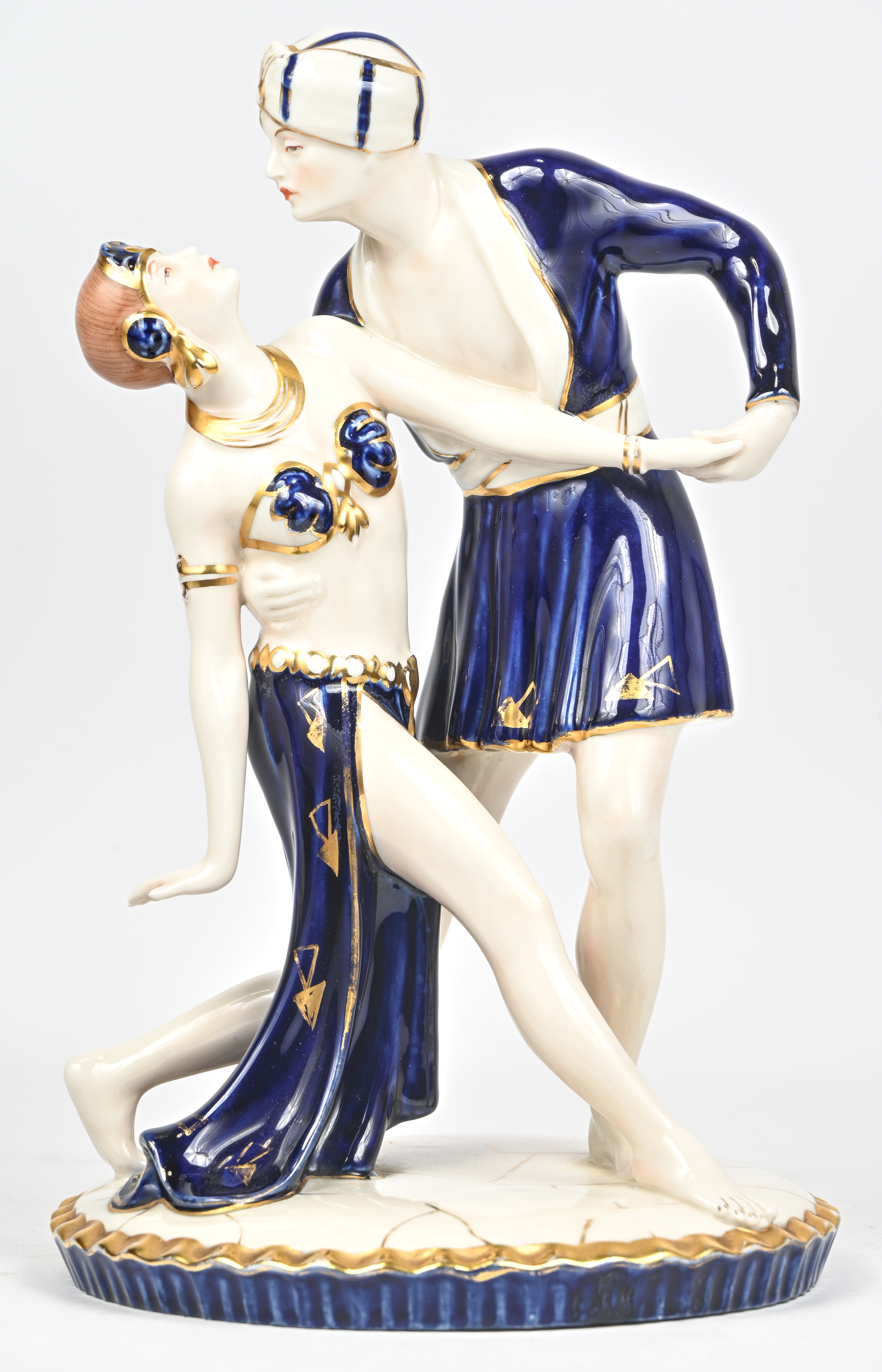 Een vintage porseleinen beeldje van een dansend paar, meerkleurig met vergulde elementen. Onderaan gemerkt.