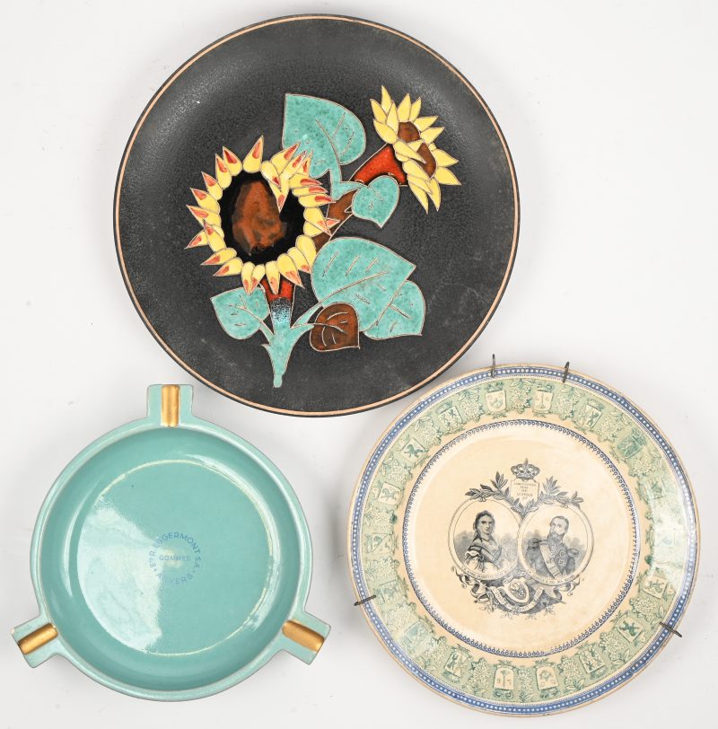 Een aardewerken asbak en twee diverse aardewerken borden.
