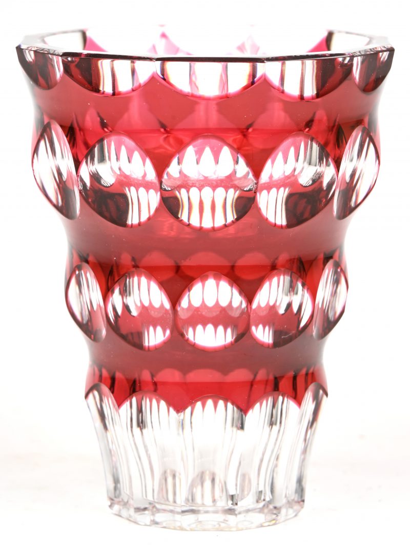 Een vaas van geslepen kristal, in de massa rood gekleurd. Onderaan gemerkt en met label.