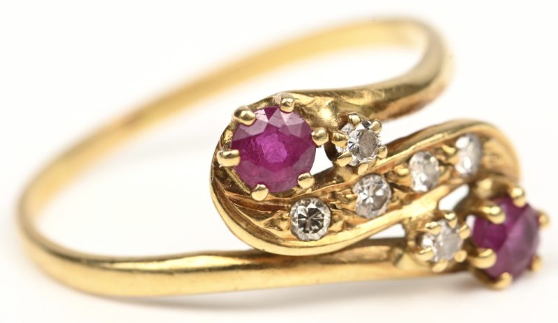Een 18 kt geelgouden ring bezet met diamanten met een gezamenlijk gewicht van +- 0,10 ct. en twee robijnen met een gezamenlijk gewicht van +- 0,20 ct.