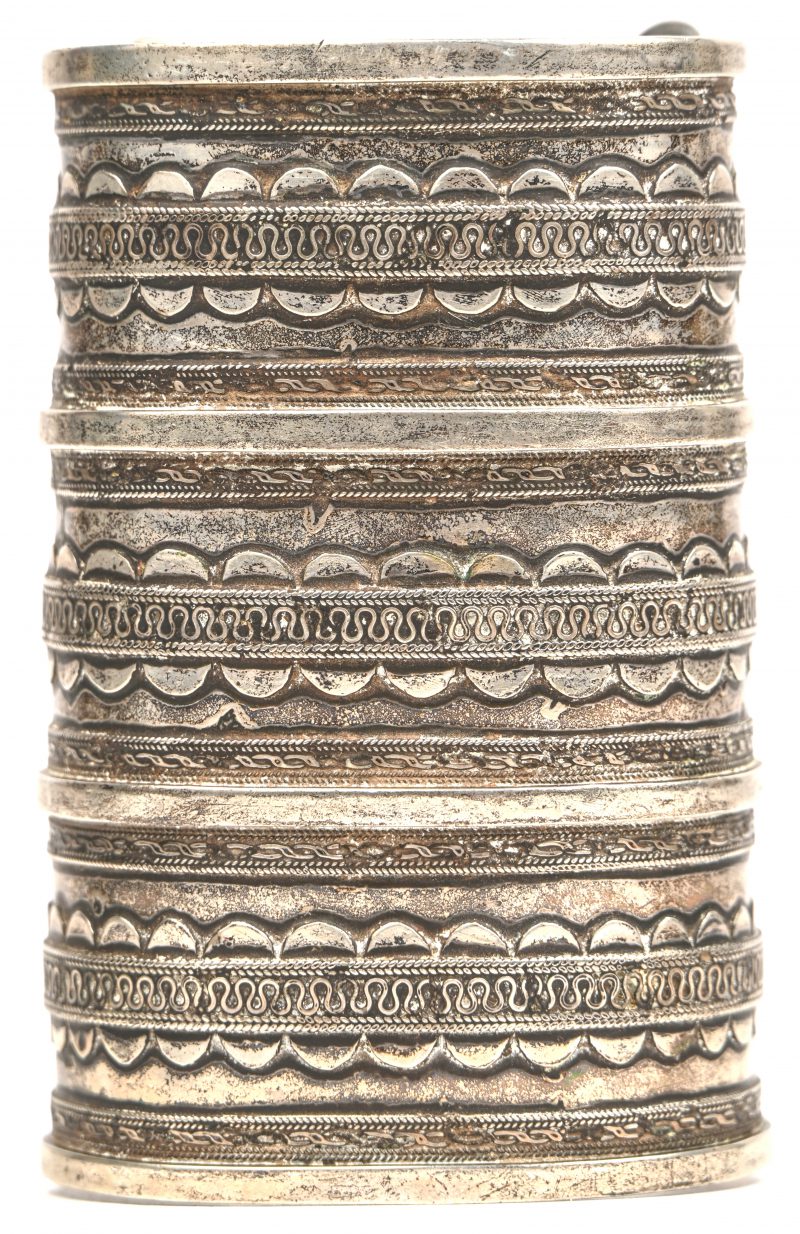 Een Nepalese zilveren armband met gesculpteerde patronen in het reliëf.