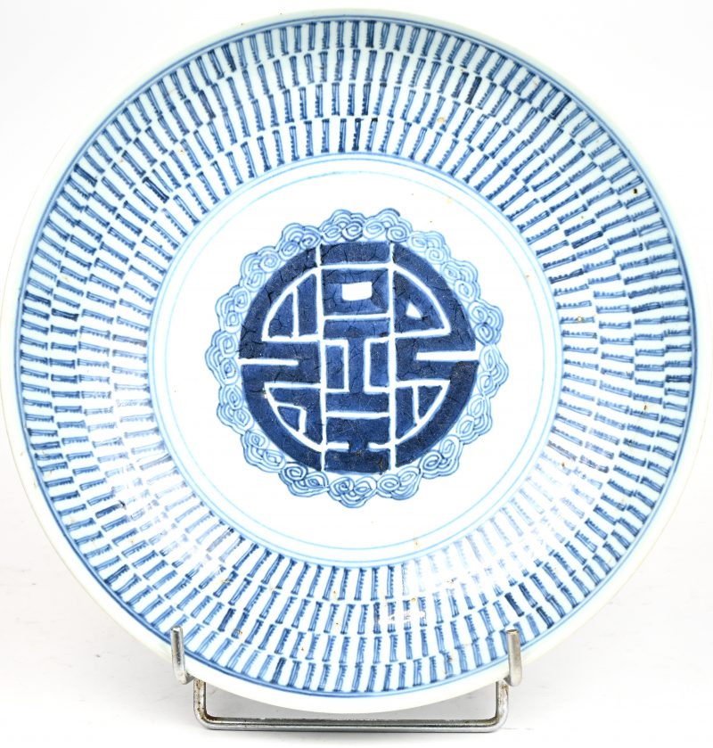 Een blauw-wit Chinees porseleinen bord met Shou symbool en symmetrisch patroon versierd. Vermoedelijk Qing Dynastie.