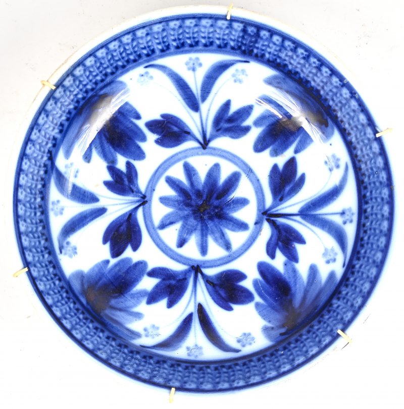Een blauw-wit Maastrichts aardewerken bord met floraal decor. Onderaan gemerkt.