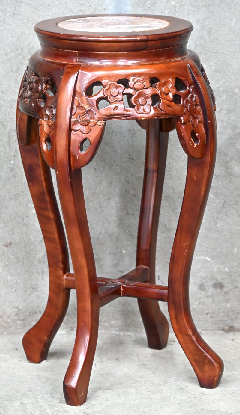 Een Chinese pied-de-stal in gesculpteerd hout en marmeren blaadje.