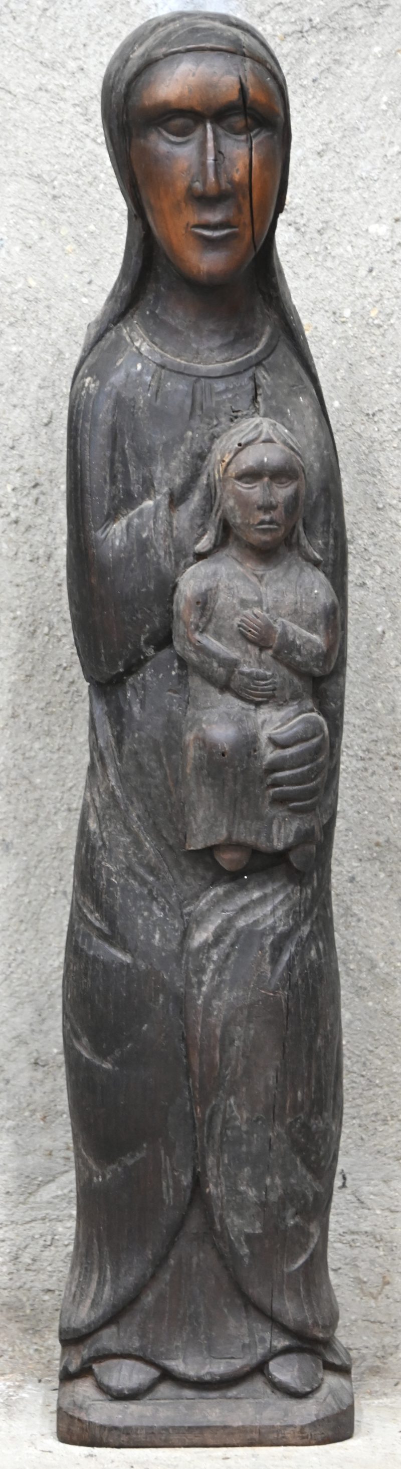 Een houten beeld van een Madonna met Kind naar Romaans voorbeeld.