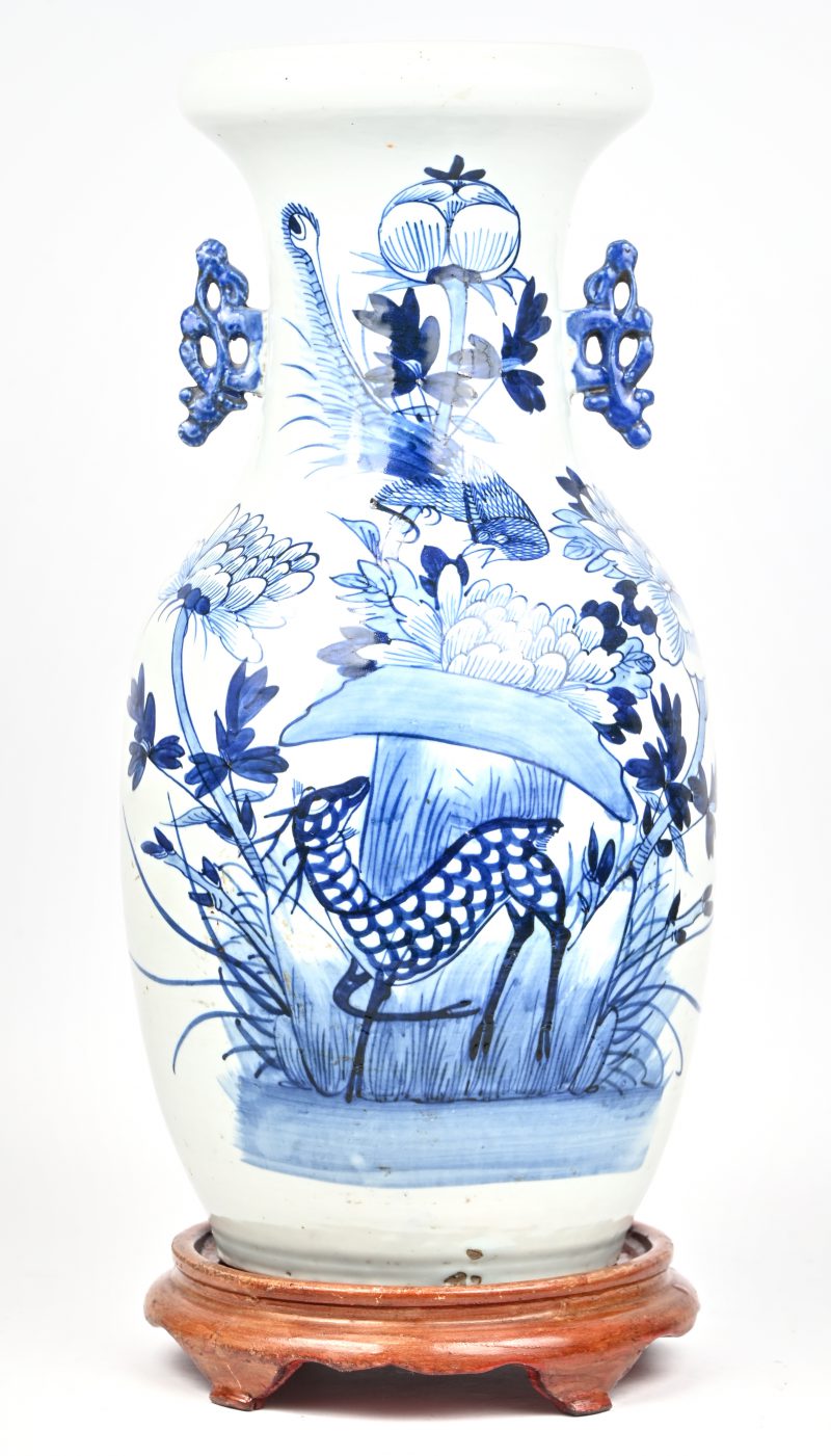 Een ballustervaas van Chinees porselein met een blauw en wit decor van een hert en bloemen. Op een houten sokkel en met uitvoercertificaat. XIXe eeuw.