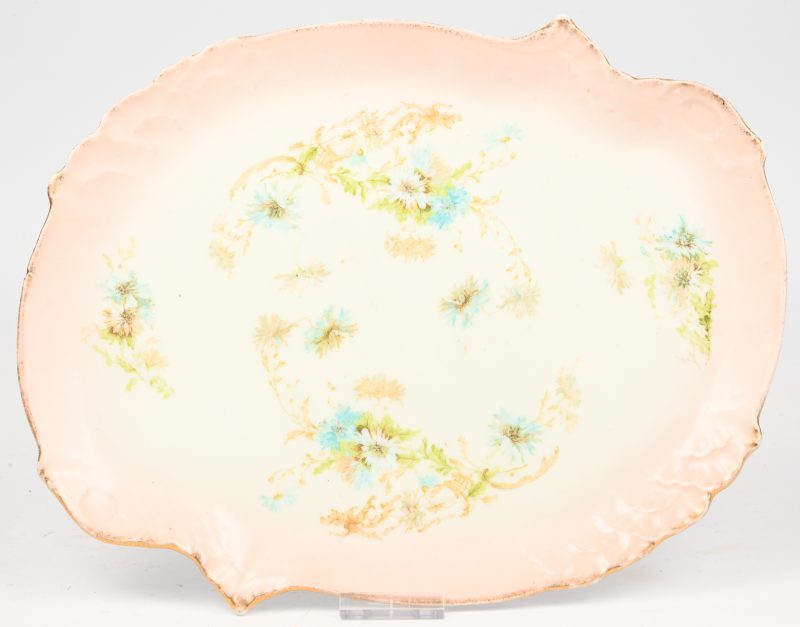 Een porseleinen schotel met floraal decor. Verso gemerkt.