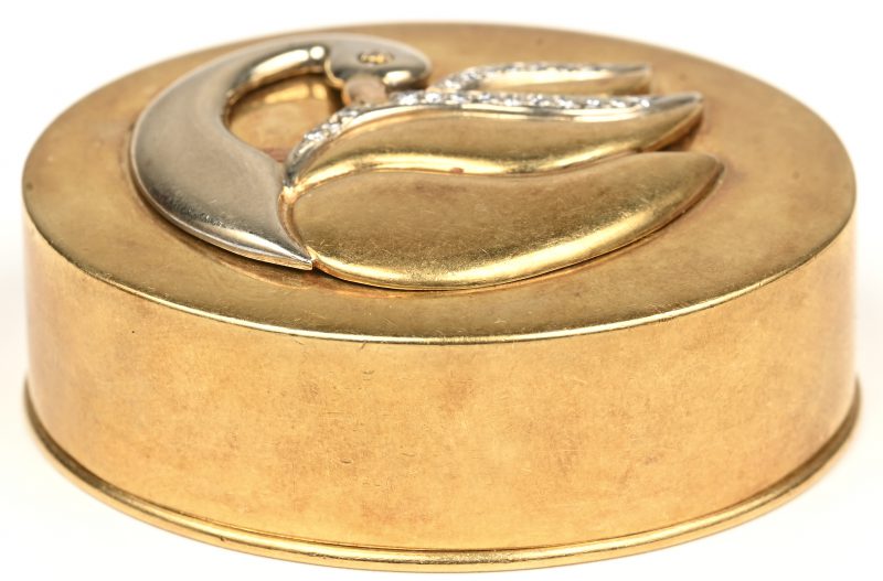Een 18 kt geelgouden pillendoos met versiering van een zwaan bezet met diamanten met een gezamenlijk gewicht van +- 0,20 ct.