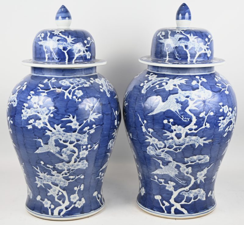 Een paar Chinees blauw porseleinen dekselpotten met floraal decor.