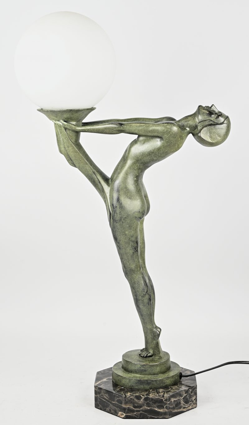 Een bronzen stalamp op marmeren voet en melkglazen bol in Art Deco stijl.