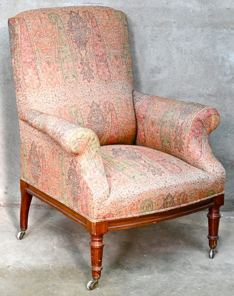Een Engelse armfauteuil met mahonie frame en gestoffeerde zitting, op 4 wieltjes. Laat Victoriaanse stijl.