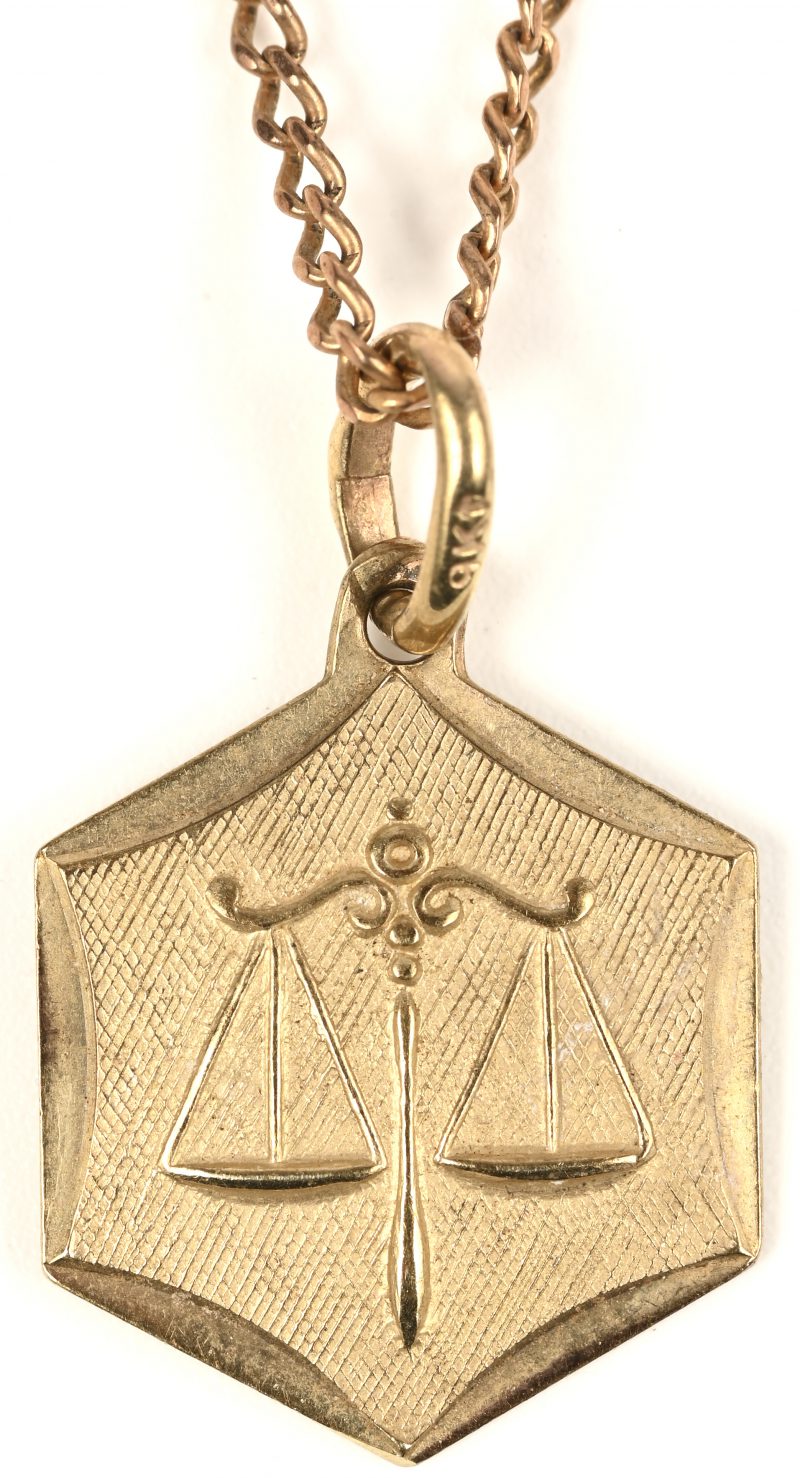 Een 9 kt geelgouden ketting met hanger met weegschaal horoscoop.