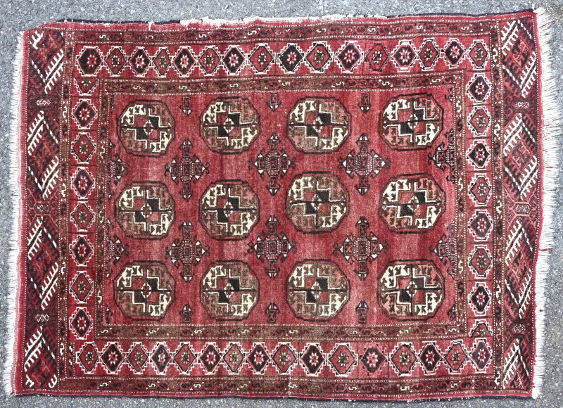 Een handgeknoopt wollen karpet met een Yomudmotief. Randslijtage.