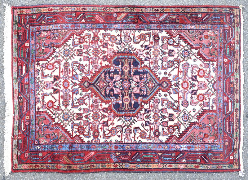 Een handgeknoopt Oosters karpet van wol met een centraal medaillon.