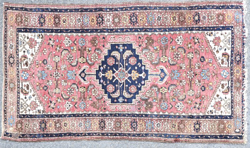 Een handgeknoopt Oosters karpet van wol met een geometrisch motief.