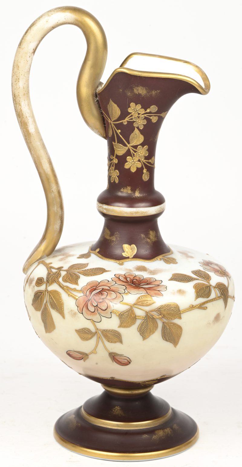 Een oud porseleinen schenkkannetje met florale motieven deels in goudverf handbeschilderd. Onderaan genummerd.