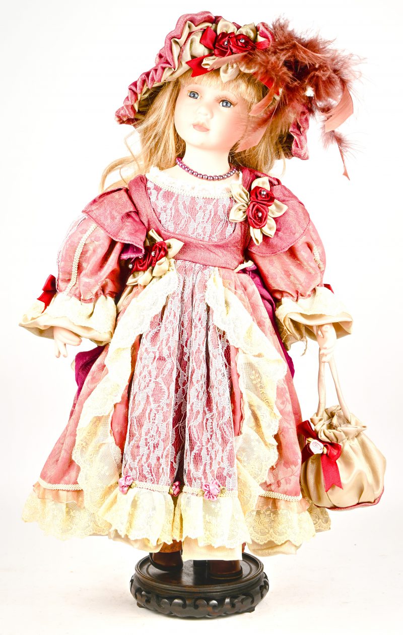 Een porseleinen pop in weelderige klederdracht.