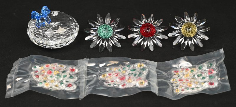 Een lot van 3 kristallen bloemen met toebehoren en originele etui. We voegen er een kristallen hartvormig doosje aan toe met vulsel.