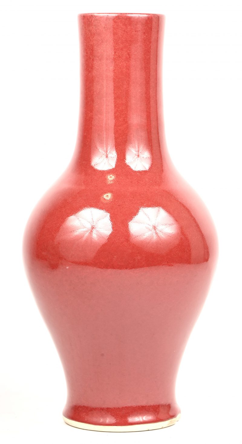 Een roodkleurig Chinees porseleinen vaas.