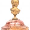 Een verguld bronzen buste van een kinderhoofje op marmeren voet. In de schouder gesigneerd.